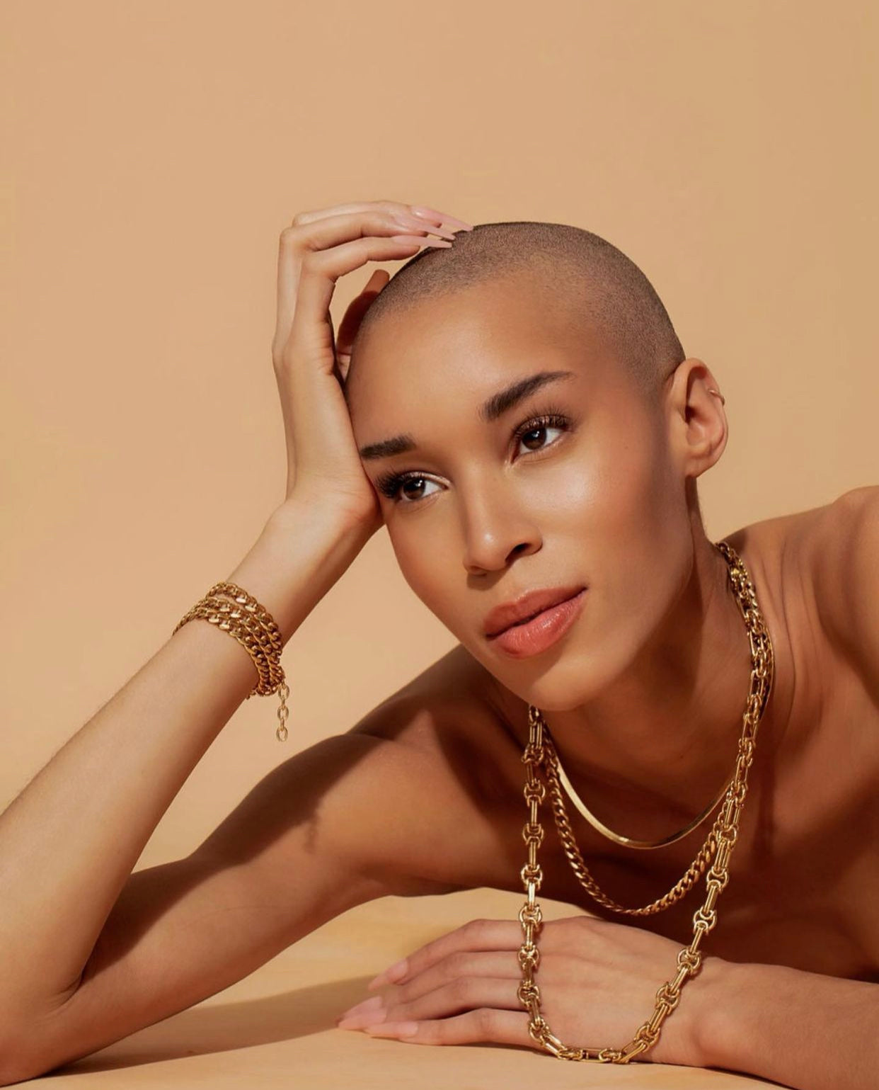 model wearing layers of gold chain jewelry