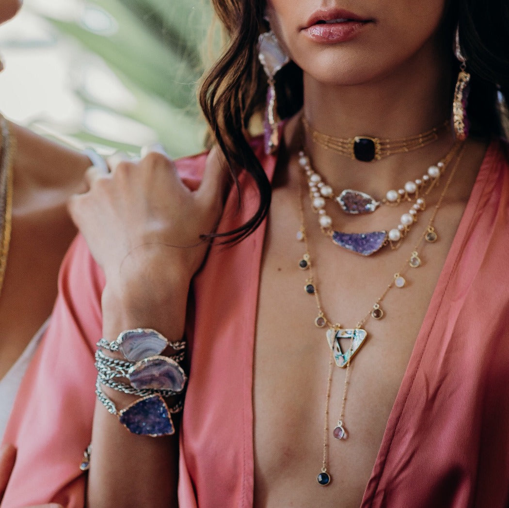 layered pearl and drusy necklaces on model wear deep v neckline