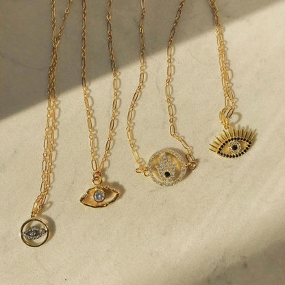 Rachel Mulherin gold and black CZ evil eye necklace with eyelashes and other layering necklaces