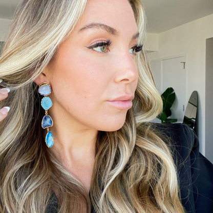 blue geode and gold statement earrings on blonde